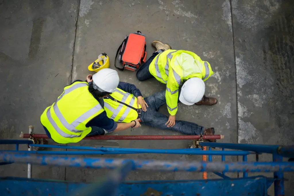 A worker laying getting medical attention from other workers.