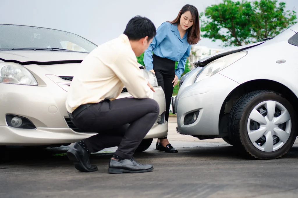 Two people looking at a car accident.