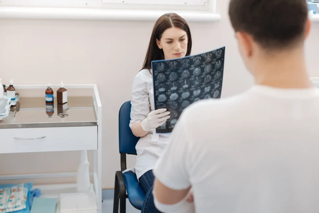 A doctor looking at an MRI with the patient present.